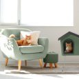 Cute red cat lying on grey armchair in living room